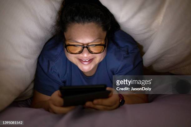 reading under the covers - glowing book stock pictures, royalty-free photos & images