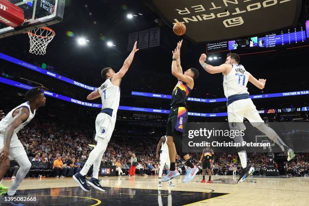 Devin Booker of the Phoenix Suns attempts a shot against Dwight Powell and Luka Doncic of the Dallas Mavericks during the second half of Game One of...