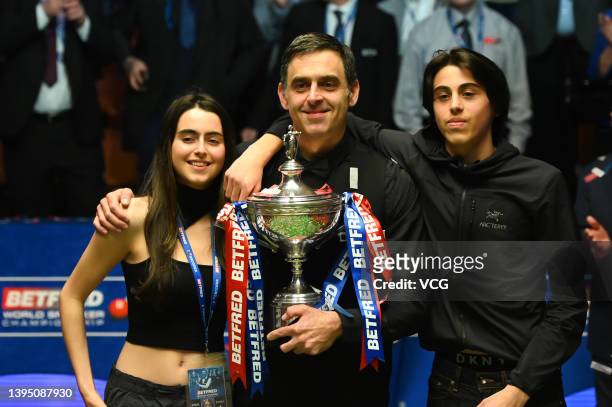 Ronnie O'Sullivan of England, his daughter Lily O'Sullivan and son Ronnie O'Sullivan Junior celebrate with the trophy after his victory over Judd...