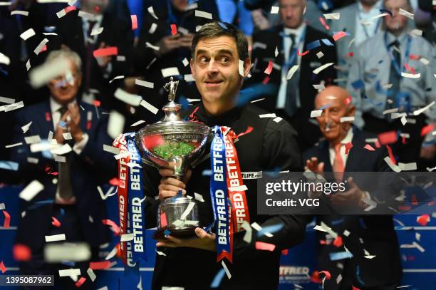 Ronnie O'Sullivan of England celebrates with the trophy after winning the final match against Judd Trump of England on day 17 of the Betfred World...