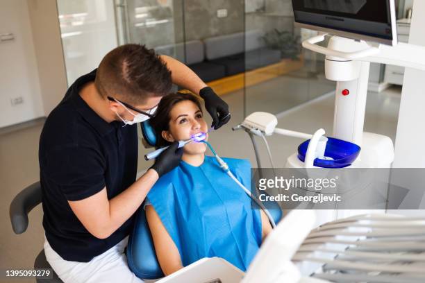 dental treatment with uv lamp - filling stockfoto's en -beelden