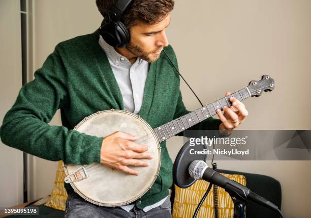 man playing banjo in his home recording studio - virtual concert stock pictures, royalty-free photos & images