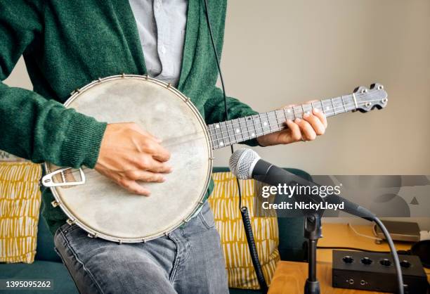 man playing the banjo into a microphone at recording studio - virtual concert stock pictures, royalty-free photos & images