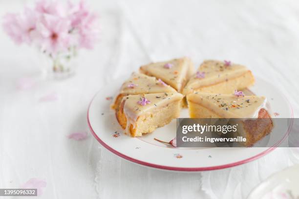 sliced cake with white chocolate icing and flowers - cake slices stock-fotos und bilder