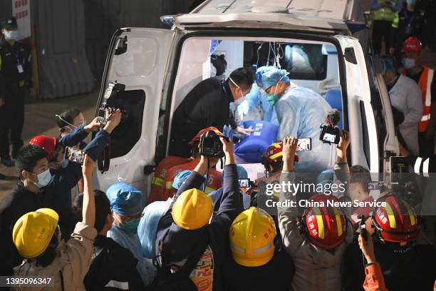 Reporters take photos as a survivor was carried onto an ambulance at the collapse site of a self-constructed residential building on May 2, 2022 in...