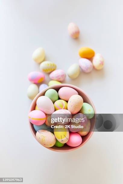 a pink bowl of brightly colored decorated easter eggs - 復活蛋 個照片及圖片檔