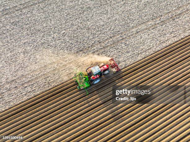 tractor pplanting potato seeldings in the soil during springtime - plowed field stock pictures, royalty-free photos & images