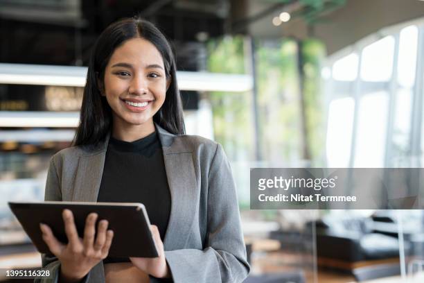 empowering women business entrepreneurs through information and communications technology solution. portrait of a young businesswomen using a tablet in a financial business office. - hotel manager stockfoto's en -beelden