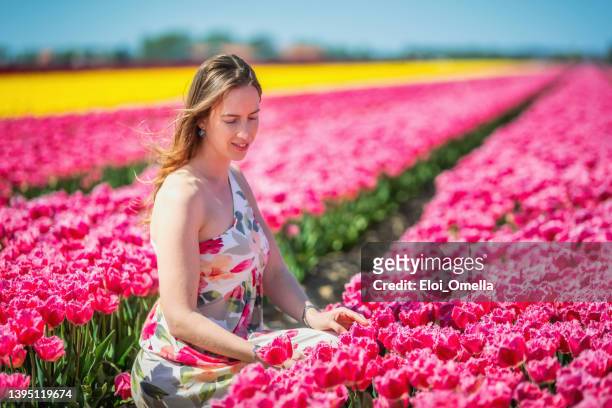 dutch woman enjoying the spring in the tulip field in netherlands - tulips amsterdam stock pictures, royalty-free photos & images