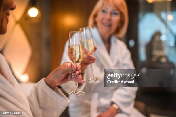 toasting to friendship in fluffy hotel bathrobes - bathrobe stock pictures, royalty-free photos & images