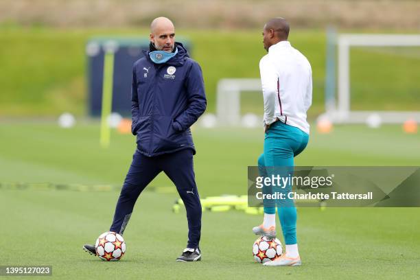 Pep Guardiola, Manager of Manchester City speaks with Fernandinho of Manchester City during a training session at Manchester City Football Academy on...