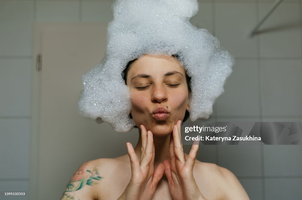 A girl having fun in a bath with foam