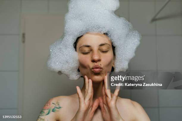 a girl having fun in a bath with foam - wasser und spaß und erwachsene stock-fotos und bilder