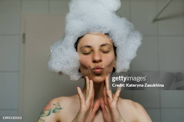 a girl having fun in a bath with foam - bubble bath foto e immagini stock