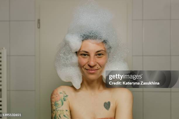 a girl having fun in a bath with foam - soap stock-fotos und bilder