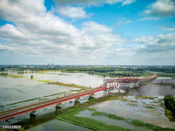 ponte de trem hanzeboog sobre o rio ijssel com alto nível de água - levee - fotografias e filmes do acervo