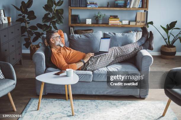 mature man working from home - feet up stock pictures, royalty-free photos & images