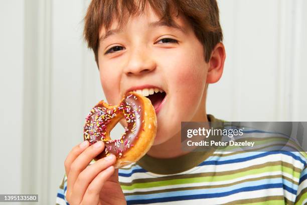 10 year old eating doughnut - fat people eating donuts stock pictures, royalty-free photos & images