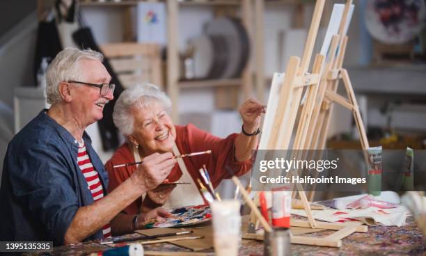 happy senior friends painting together at art class. - actividad fotografías e imágenes de stock