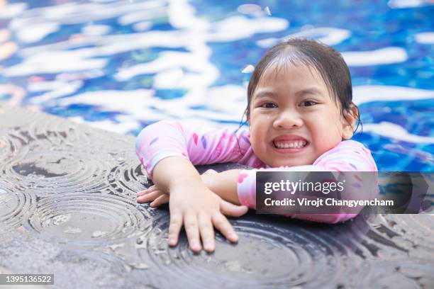 happy little girl in swimming pool - one piece stock pictures, royalty-free photos & images