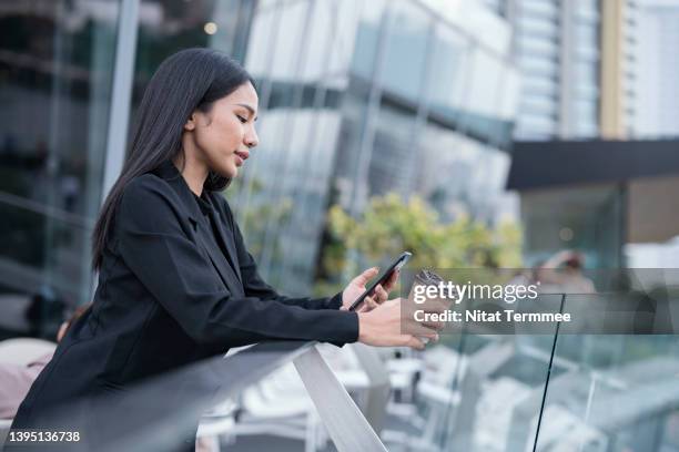 technology can manage your appointment schedule easier. side view of a young businesswoman checking appointment messages on smartphone and holding coffee cup during business trip in central business district. - personal organizer bildbanksfoton och bilder