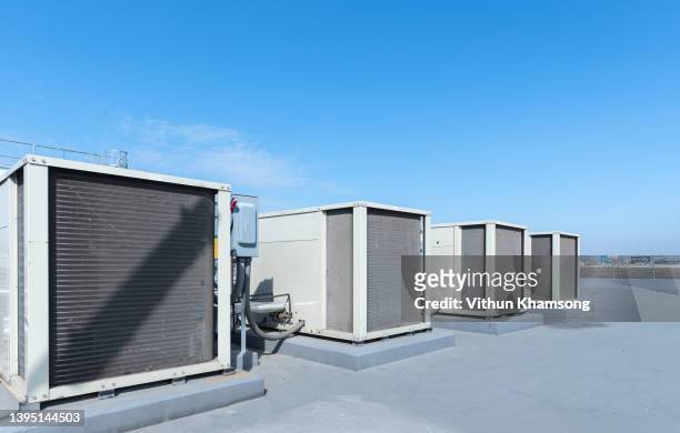 air compressor machine part of air conditioner system on roof deck with sky background at factory. - fan of his work stock pictures, royalty-free photos & images