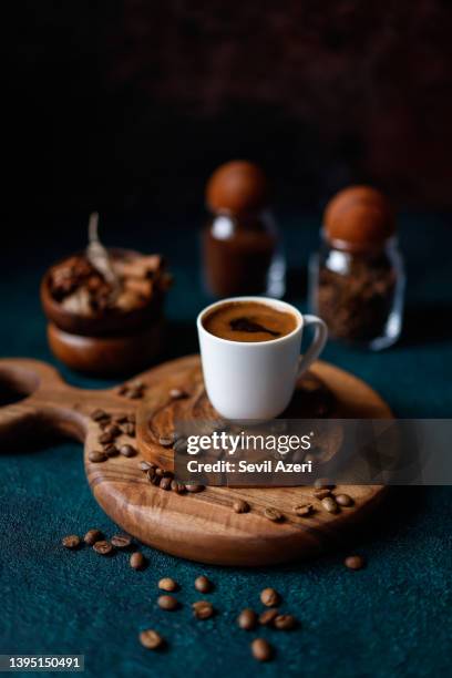 a frothy turkish coffee in a white cup on a round wooden cutting board on a dark turquoise green-blue rough concrete floor - turkish coffee drink stock pictures, royalty-free photos & images