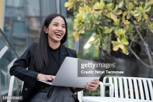 Shift Negative Thoughts Into a Positive Mindset for Creative Thinking in Young Business Entrepreneurs. Shot of Young Businesswomen is laughing while working on a laptop to discussion with her team outside the business office. Shift Negative Thoughts Into a Positive Mindset for Creative Thinking in Young Business Entrepreneurs. Shot of Young Businesswomen is laughing while working on a laptop to discussion with her team outside the business office.