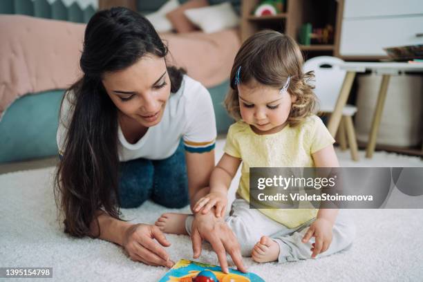 mom and her little girl spending time together at home. - baby sitting stock pictures, royalty-free photos & images