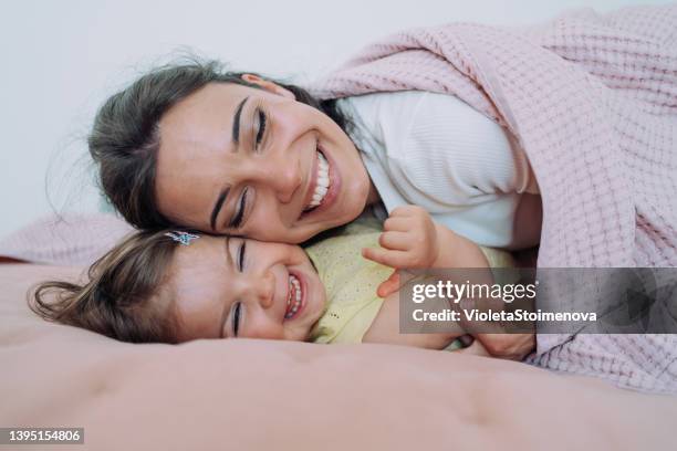 affectionate mother and daughter embracing at home. - baby blankets stockfoto's en -beelden