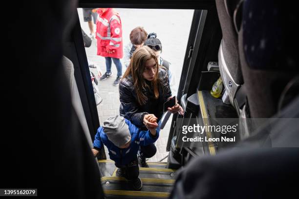 Young woman and child board a bus, just before it leaves for Warsaw in Poland, carrying refugees from regions of Southern and Eastern Ukraine,...