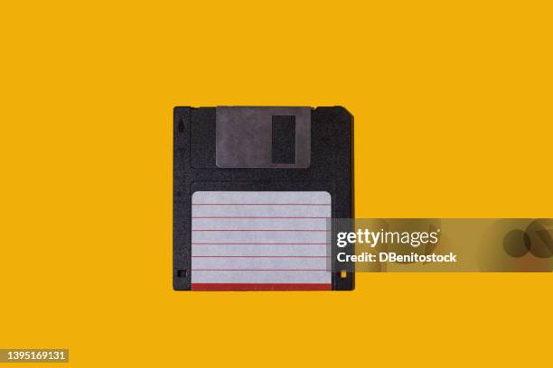 black retro 3.5" floppy diskette with white and red label on yellow background. concept of computing, computer, storage, vintage, disk and data storage. - computer disks stock pictures, royalty-free photos & images
