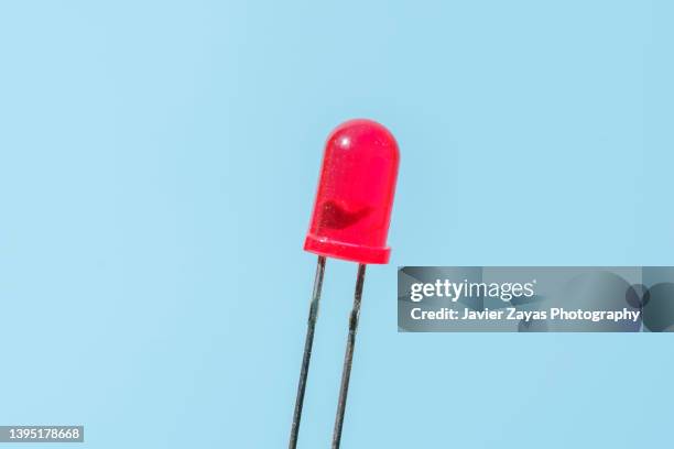 red led light on blue background - red light bulb stock pictures, royalty-free photos & images