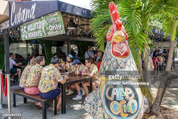 Little Havana, Miami, Florida, giant fiberglass rooster sculpture outside crowded El Pub restaurant.