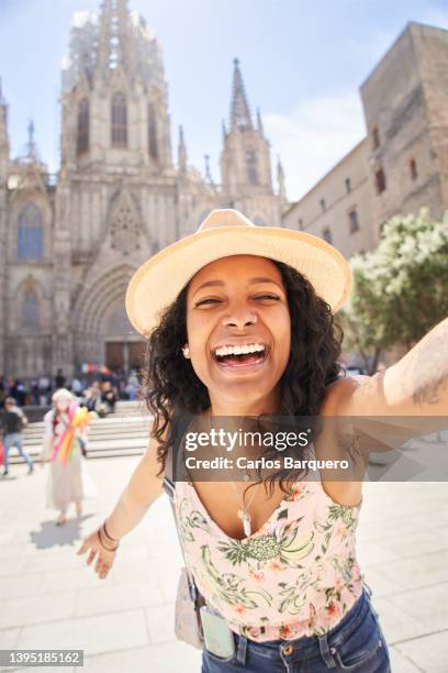 vertical portrait of a happy tourist woman taking a selfie at barcelona cathedral square. - selfie young people photos et images de collection