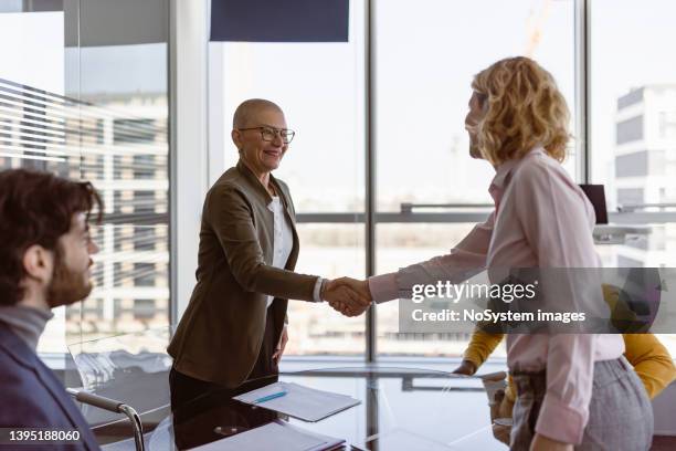 stretta di mano della donna d'affari dopo la firma del contratto - shareholder foto e immagini stock