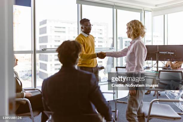 businesspeople handshake after contract signing - shareholder stock pictures, royalty-free photos & images