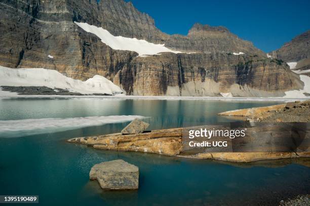 Glacial tarn and melting ice. Grinnell Glacier, northern Montana. Bedrock consists of the Proterozoic Helena Dolomite of the Belt Supergroup. The...