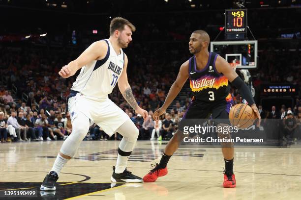 Chris Paul of the Phoenix Suns handles the ball against Luka Doncic of the Dallas Mavericks during the second half of Game One of the Western...