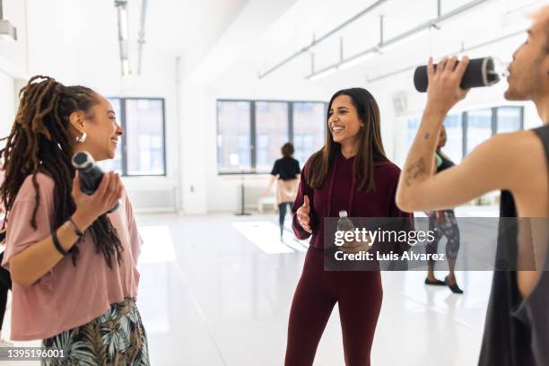 women in sportswear having a break at dance studio - dreadlocks stockfoto's en -beelden