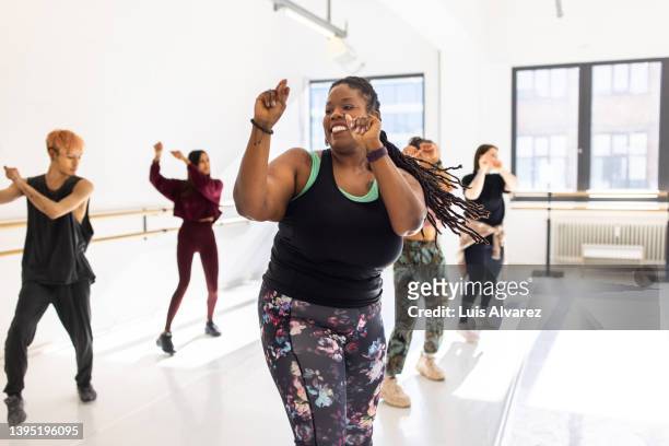 african woman doing zumba dance in fitness class - dancers exercising teacher stockfoto's en -beelden