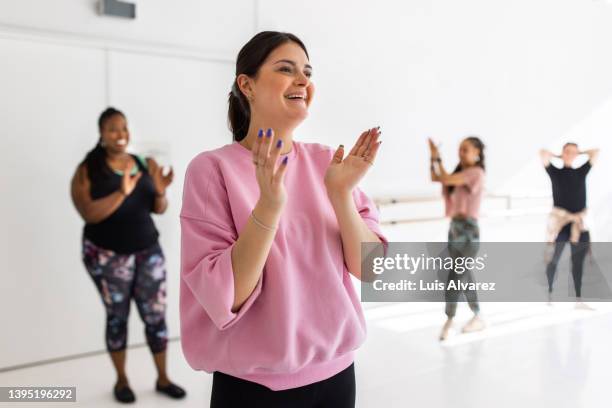 woman clapping hands after a dance routine at fitness class - woman dance studio stock pictures, royalty-free photos & images