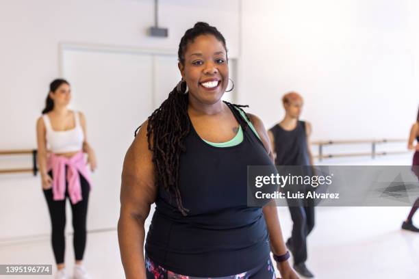 portrait of a smiling plus size woman at fitness dance class - images of fat black women stock-fotos und bilder