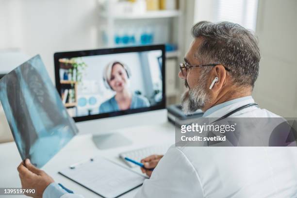 médico reuniéndose de forma remota con su paciente - remote location fotografías e imágenes de stock