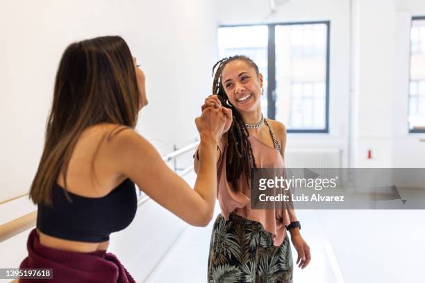 women friends high fiving after a dance workout in fitness studio - hi five gym foto e immagini stock