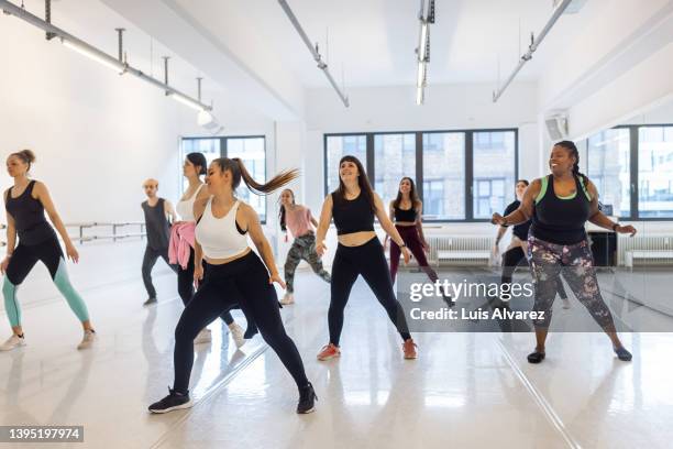 multiracial women enjoy a dance routine at health club - dancers exercising teacher stockfoto's en -beelden