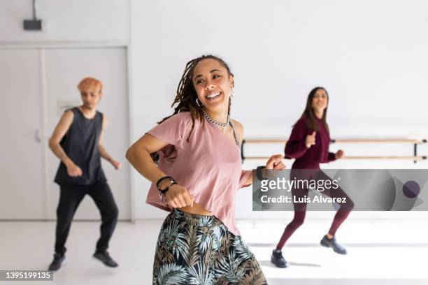 smiling young woman doing dance in fitness studio - dance fitness stock-fotos und bilder
