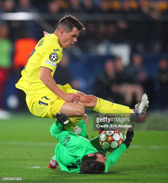 Giovani Lo Celso of Villarreal CF is challenged by Alisson Becker of Liverpool during the UEFA Champions League Semi Final Leg Two match between...