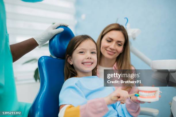 kleines mädchen, die ein zahnarzt - pediatric dentistry stock-fotos und bilder