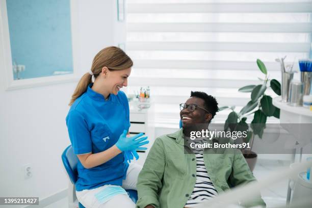 a professional dentist telling his patient good news - dental equipment stock pictures, royalty-free photos & images